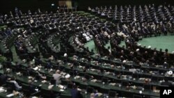 FILE - Participants listen to a speaker during the swearing-in ceremony of Iranian President Ebrahim Raisi at the parliament in Tehran, Iran, Aug. 5, 2021. 