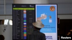FILE - A man checks departure information on a display screen at Faro airport amid the coronavirus disease (COVID-19) pandemic, in Faro, Portugal, June 6, 2021. 