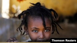 FILE - An Ethiopian girl stands at the window of a temporary shelter, at the Village 8 refugees transit camp, which houses Ethiopian refugees fleeing the fighting in the Tigray region, near the Sudan-Ethiopia border.