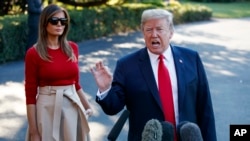 President Donald Trump speaks with reporters before boarding Marine One on the South Lawn of the White House as First lady Melania Trump looks on, July 10, 2018, in Washington. 