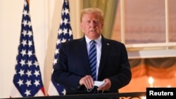 ប្រធានាធិបតីសហរដ្ឋអាមេរិកលោក Donald Trump ឈរនៅមុខសេតវិមាន បន្ទាប់ពីលោកបានចាកចេញពីមន្ទីរពេទ្យយោធា Walter Reed ត្រឡប់ទៅសេតវិមានវិញ កាលពីថ្ងៃទី ៥ ខែតុលា ឆ្នាំ២០២០។