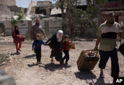 A girl ducks as she flees with her brothers in the al-Rifai neighborhood as Iraqi special forces battle Islamic State militants in western Mosul, Iraq, May 17, 2017.