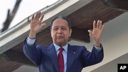 Mantan diktator Haiti, Jean-Claude 'Baby Doc' Duvalier, melambaikan tangan pada para pendukung di rumah kontrakan tempat ia tinggal di Port-au-Prince.