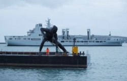 Patung perunggu terbesar Inggris, "Messenger" saat 'transit' di Plymouth Sound dengan tongkang, sebelum dibawa melalui jalan darat ke Theatre Royal di Plymouth, Inggris, 18 Maret 2019. (REUTERS / Peter Nicholls)