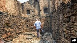 A man looks at the destruction caused by wildfires near the Mediterranean coastal town of Manavgat, Antalya, Turkey, July 30, 2021.