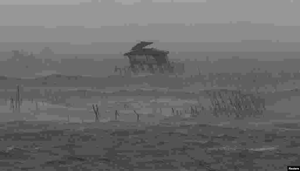 Rumah panggung milik nelayan di tengah laut miring dihantam ombak, angin kencang dan hujan yang dibawa Topan Rammasun yang menghantam kota pesisir Bacoor, di Cavite, barat daya Manila (16/7). (Reuters/Erik De Castro)