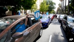 In this Aug. 28, 2019, file photo, dozens of supporters of a measure to limit when companies can label workers as independent contractors circle the Capitol during a rally in Sacramento, Calif. (AP Photo/Rich Pedroncelli, File)