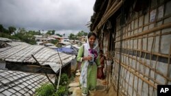 In this Aug. 27, 2018, photo, Rahima Akter walks through Balukhali refugee camp in Bangladesh. Rahima is a 19-year-old refugee who dreams of becoming the most educated Rohingya woman in the world. She recently finished high school and hopes to study human rights in college. (AP Photo/Altaf Qadri)