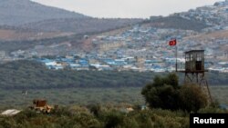 FILE - A Turkish military armored vehicle patrols on the border line located opposite the Syrian town of Atimah, Idlib province, in this picture taken from Reyhanli, Hatay province, Turkey Oct. 10, 2017.
