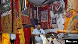 FILE - A Tibetan artisan makes traditional wall decorations inside his workshop at Majnu Ka Tila, a Tibetan refugee camp in New Delhi, India, April 27, 2016.