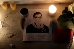 Candles and an image of late U.S. Supreme Court Justice Ruth Bader Ginsburg are seen as people gather in front of the U.S. Supreme Court following her death, in Washington, Sept. 19, 2020.