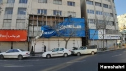 A Samsung Electronics advertising banner is taken down from a home appliance storefront in Tehran, in this image published Feb. 13, 2020 by Iran's state-approved Hamshahri newspaper.