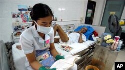 A nurse, wearing protective mask an gloves reads to a HIV/AIDS patient at the Phra Baht Nam Phu AIDS hospice near Lopburi, Thailand (File)