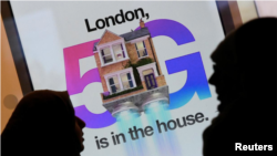 Pedestrians walk past an advertisement promoting the 5G data network at a mobile phone store in London, Britain, January 28, 2020. (REUTERS/Toby Melville)