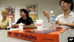 FILE - Yoshihiko Iwasaki from Japan, right, speaks during a Test of English as a Foreign Language, TOEFL, class at Kaplan, a test-prep school, in Boston, Thursday, Sept. 22, 2005, as his classmates Merve Hatiboglu of Turkey, left, and Jose Bello of Braz