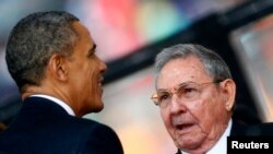 Presiden Amerika Barack Obama menyapa Presiden Kuba Raul Castro di upacara penghormatan bagi Nelson Mandela, 10 Desember 2013.