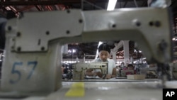 In this photo taken Saturday, April 21, 2012, young workers use sewing machines at a garment factory in Yangon, Myanmar. On Monday, April 23, 2012.