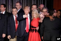 FILE - Then President-elect Donald Trump and campaign manager Kellyanne Conway celebrate during an election night rally.