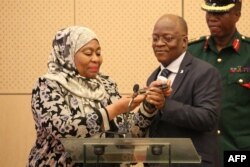 Makamu Rais Samia Suluhu wa Tanzania na Rais John Magufuli wakizungumza kwa simu na Rais Kenyatta, Machi 17, 2021. (Photo by Ericky BONIPHACE / AFP)