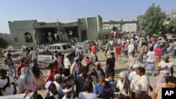 People gather at the al-Zaydiya security headquarters that was destroyed by Saudi-led airstrikes Saturday, in the Red Sea port city of Hodeida, Yemen, Sunday, Oct. 30, 2016.