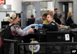 A Transportation Security Administration official works at the entrance to Concourse G at Miami International Airport in Miami, Jan. 11, 2019.