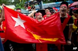 Supporters of Myanmar's National League for Democracy party brave rain outside the NLD headquarters in Yangon, Myanmar, Nov. 9, 2015.