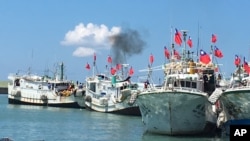 FILE - Taiwanese fishing boats flying national flags prepare to leave for the Taiwan-controlled Taiping Island from Taiwan's southern port city of Pingtung, July 20, 2016.