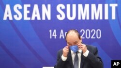 응웬 쑤원 푹 베트남 총리가 14일 아세안+한중일 화상 정상회의에서 발언하기 위해 마스크를 벗고 있다.