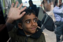 A Yemeni boy waves from inside a bus before boarding a United Nations plane at Sanaa International airport, Yemen, Feb. 3, 2020.