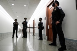 FILE - Capitol Hill police officers stand outside a Senate committee hearing room, on Capitol Hill, in Washington, Oct. 14, 2020.