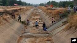 FILE - In this March 28, 2016 photo, Thai workers repair a dried up irrigation canal at Chai Nat province, Thailand. Much of Southeast Asia is suffering its worst drought in 20 or more years. (AP Photo/Sakchai Lalit)