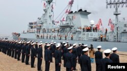 Chinese navy officers (backs to camera) stand in formation as Pakistan naval frigate Shamsher arrives at a military port before a maritime drill during the Western Pacific Naval Symposium in Qingdao, Shandong province, April 20, 2014.
