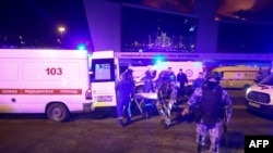 Sejunlah petugas medis dan keamanan tiba di lokasi penembakan massal di Crocus City Hall, di luar Kota Moskow, Jumat, 22 Maret 2024. (Foto: Sergei Vedyashkin/Moskva News Agency/AFP)