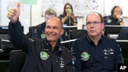 Swiss pilot and chairman of Solar Impulse Bertrand Piccard, left, gestures alongside Prince Albert II of Monaco as the solar-powered plane Solar Impulse 2 takes off from Nanjing, China, en route to Hawaii, at the Mission Control Center in Monaco, May 30, 