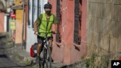 Bonifaz Diaz rides through the streets of Quetzaltenango, Guatemala, Saturday, Jan. 30, 2021. (Henning Sac via AP)