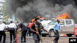 Warga berupaya memadamkan api yang membakar mobil yang dipicu oleh ledakan bom di dekat gedung Parlemen di Kampala, Uganda, 16 November 2021.