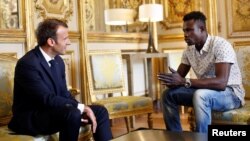 Mamoudou Gassama (kanan) berada di istana Elysée, Paris untuk menerima penghargaan dari Presiden Emmanuel Macron, Senin (28/5). 