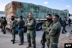 Izraelski vojnici stoje pored egipatskih kamiona natovarenih humanitarnom pomoći za Pojas Gaze, na graničnom pelazu Kerem Šalom, 6. februara 2024.