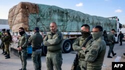 Wanajeshi wa Israel wakiwa karibu na malori ya kupeleka misaada kwenye Ukanda wa Gaza