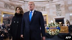 Le président américain Donald Trump, à droite, et la première dame Melania Trump quittent la rotonde du Capitole après avoir assisté à un mémorial pour l'évangéliste Billy Graham à Washington, le 28 février 2018.