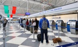 FILE - People wait at O'Hare International Airport in Chicago, Nov. 20, 2020.