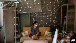 Rachelle Boumelhem sits in her damaged beauty salon in Beirut, Lebanon, Monday, Aug. 10, 2020. 