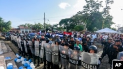 FILE - Police form a cordon outside a church where a Mass is celebrated for the freedom of political prisoners, in Masaya, Nicaragua, Aug. 28, 2019. 