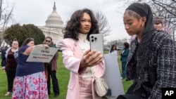 2024年3月13日，TikTok的忠实用户莫娜·斯温（Mona Swain，中）和她的妹妹瑞秋·斯温（Rachel Swain，右）（均来自亚特兰大）在国会大厦前参加一场支持TikTok的集会。美国国会众议院当天通过一项法案，如果 TikTok在中国的所有者不出售该应用程序，将在全国范围内禁止使用该流行视频应用程序。