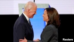 Mantan Wapres AS Joe Biden dan Senator AS Kamala Harris berjabat tangan menjelang debat kandidat Capres Demokrat di Detroit, Michigan, 31 Juli 2019. (Foto: dok).
