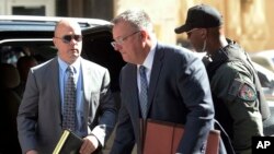 Lt. Brian Rice, left, one of the six members of the Baltimore Police Department charged in connection to the death of Freddie Gray, arrives with attorney Mike Davey, center, at a courthouse to hear a judge's ruling in his trial in Baltimore, July 18, 2016