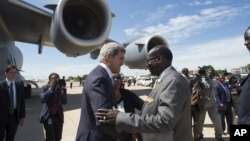 Janubiy Sudan Tashqi ishlar vaziri Barnaba Marial Benjamin Amerika bosh diplomati Jon Kerrini kutib oldi. 2-may, Juba, Janubiy Sudan.