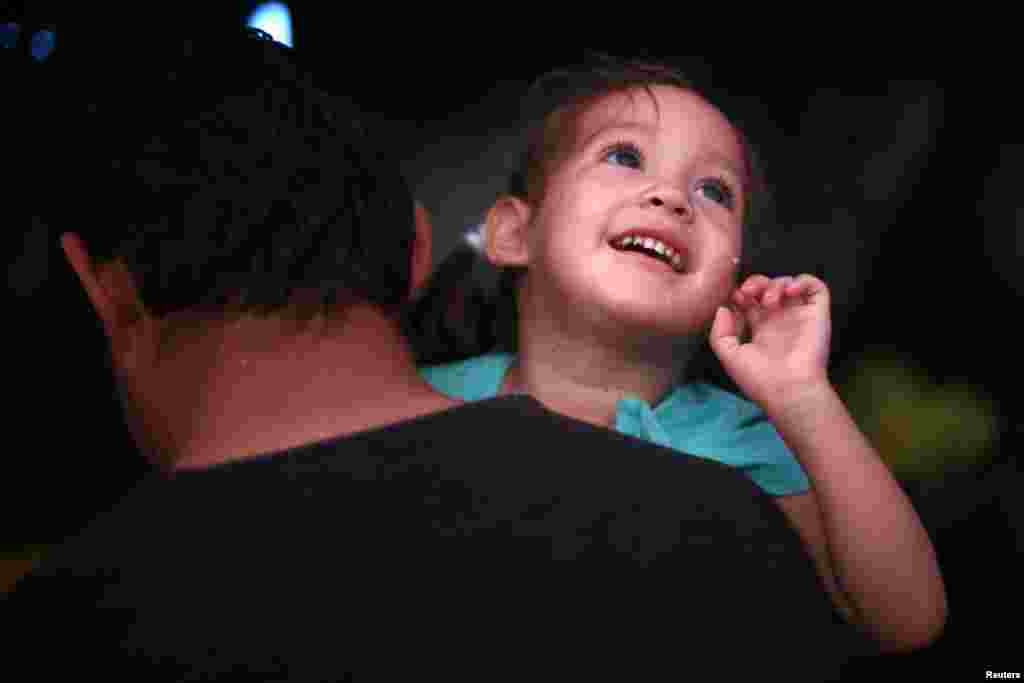 Genesis, 2, a Honduran migrant, part of a caravan trying to reach the U.S., looks on as she waits for the gate on the bridge that connects Mexico and Guatemala to open in Ciudad Hidalgo, Mexico, Oct. 21, 2018.