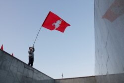 A man waves a flag during an opposition demonstration to protest against presidential election results at the Independence Square in Minsk, Belarus August 24, 2020.