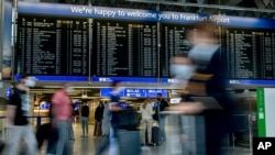 FILE - Passengers walk in a terminal at the airport in Frankfurt, Germany, Aug. 27, 2020.
